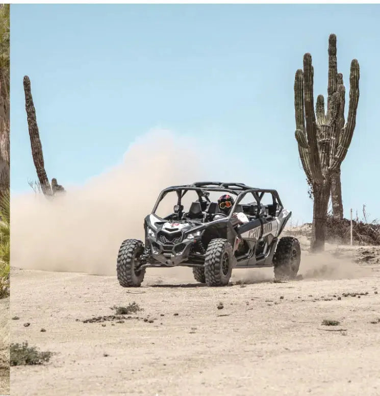 UTV kicking up dust past cardón cacti on the East Cape off-road tour, Los Cabos