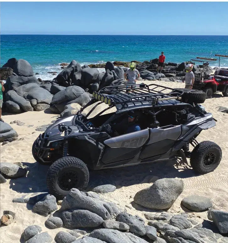 UTV parked on a rocky beach along the East Cape coastline, Wild Canyon Adventures