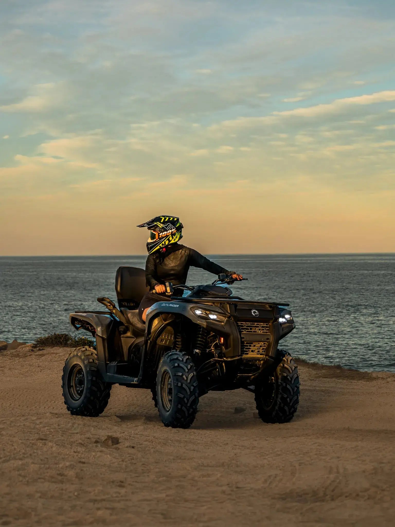 ATV rider on a Can-Am Outlander by the ocean at dusk during a Wild Canyon Adventures tour in Los Cabos