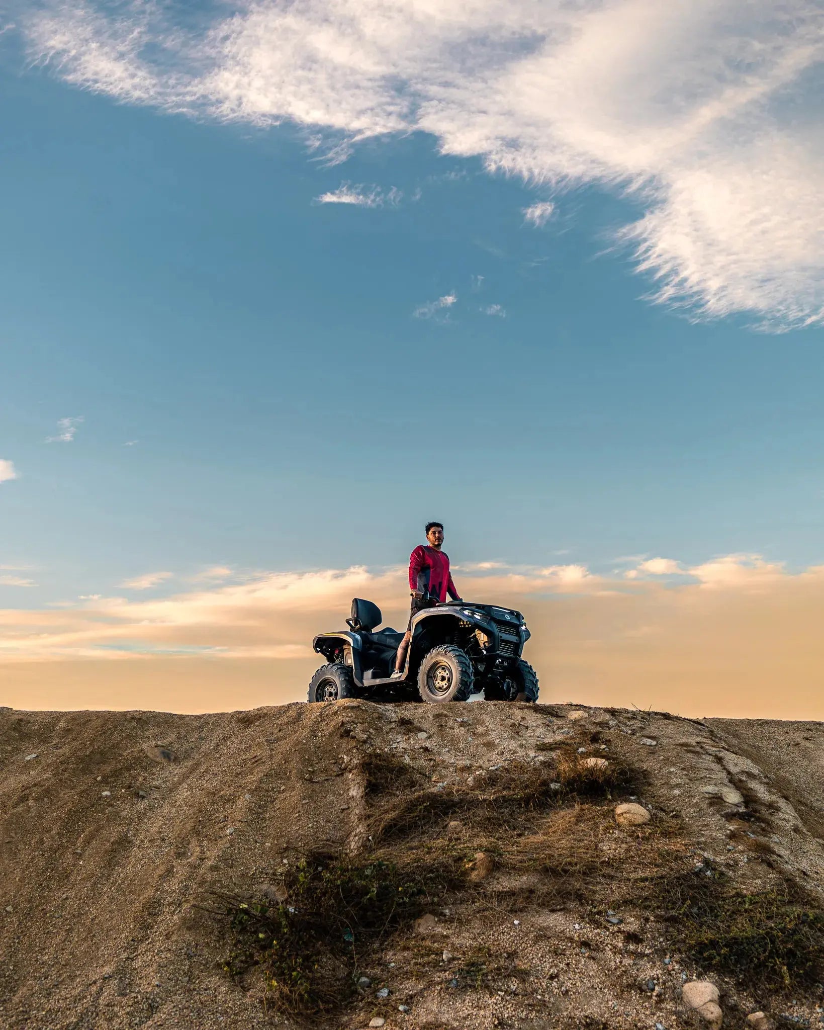 ATV rider lifting goggles on a Can-Am Outlander at sunset, Wild Canyon Adventures, Los Cabos