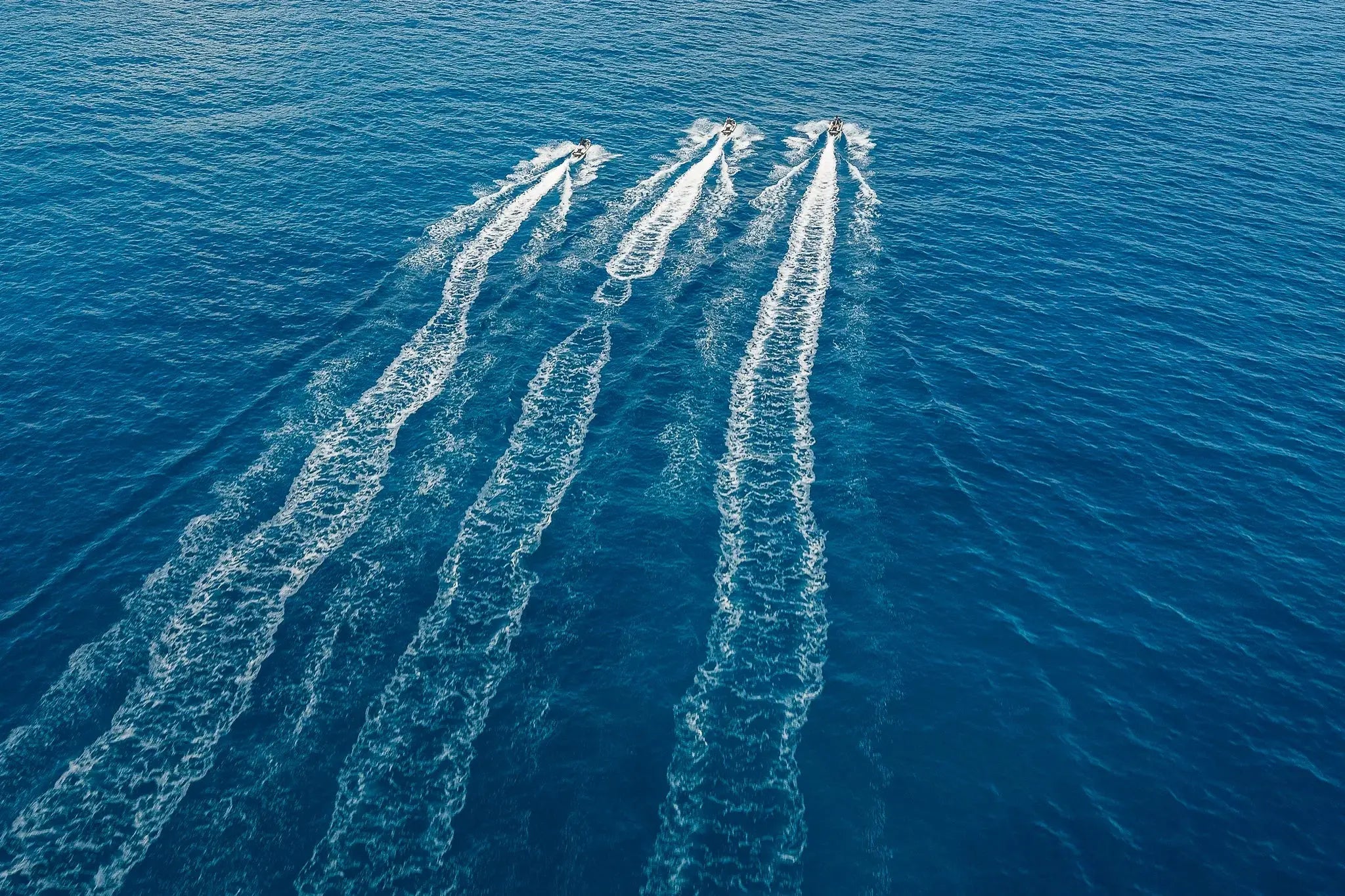 Aerial view of three Sea-Doo jet skis racing in parallel across the sea off Los Cabos, Wild Canyon Adventures