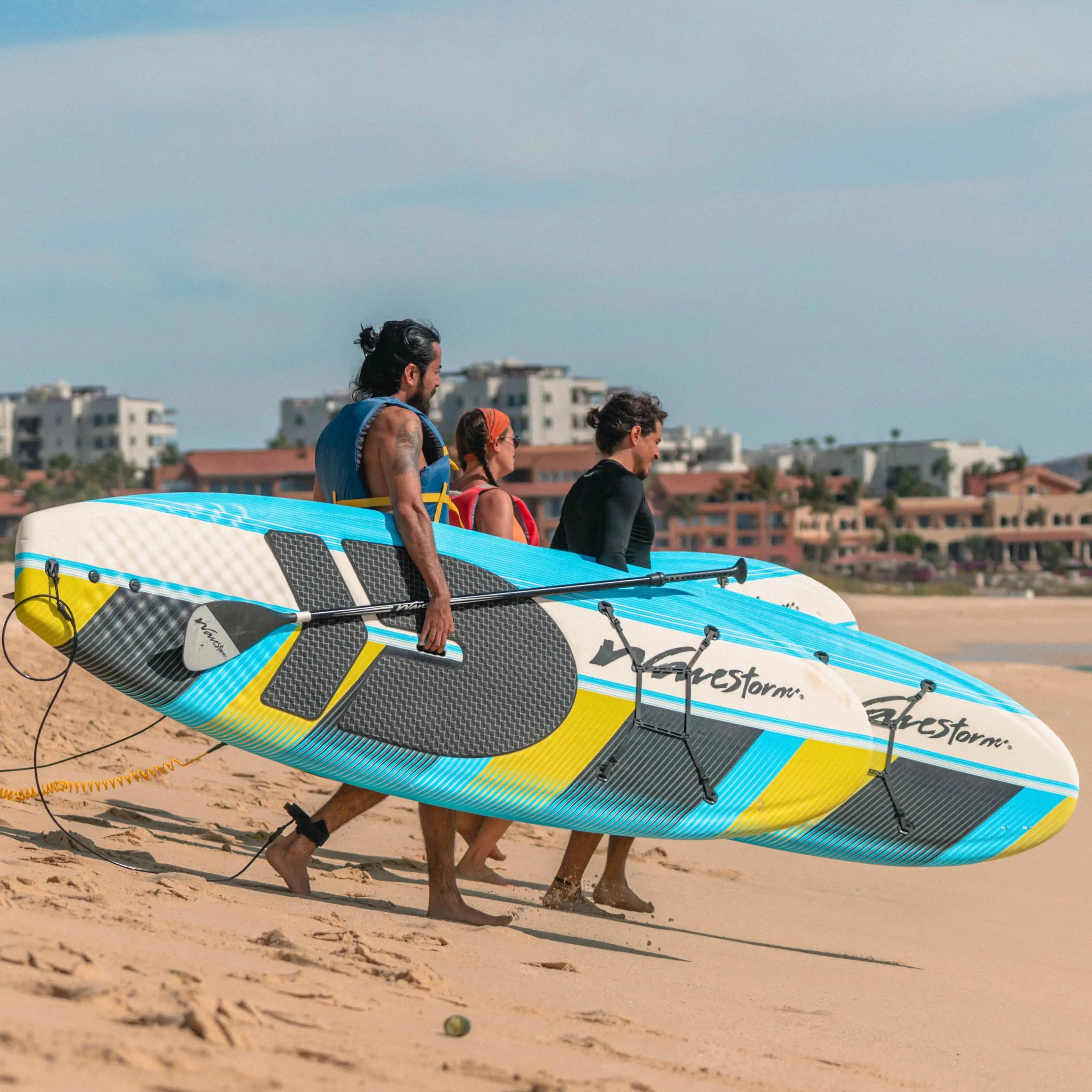 Group walking towards the sea with paddle boards - Beach Pass Wild Bay