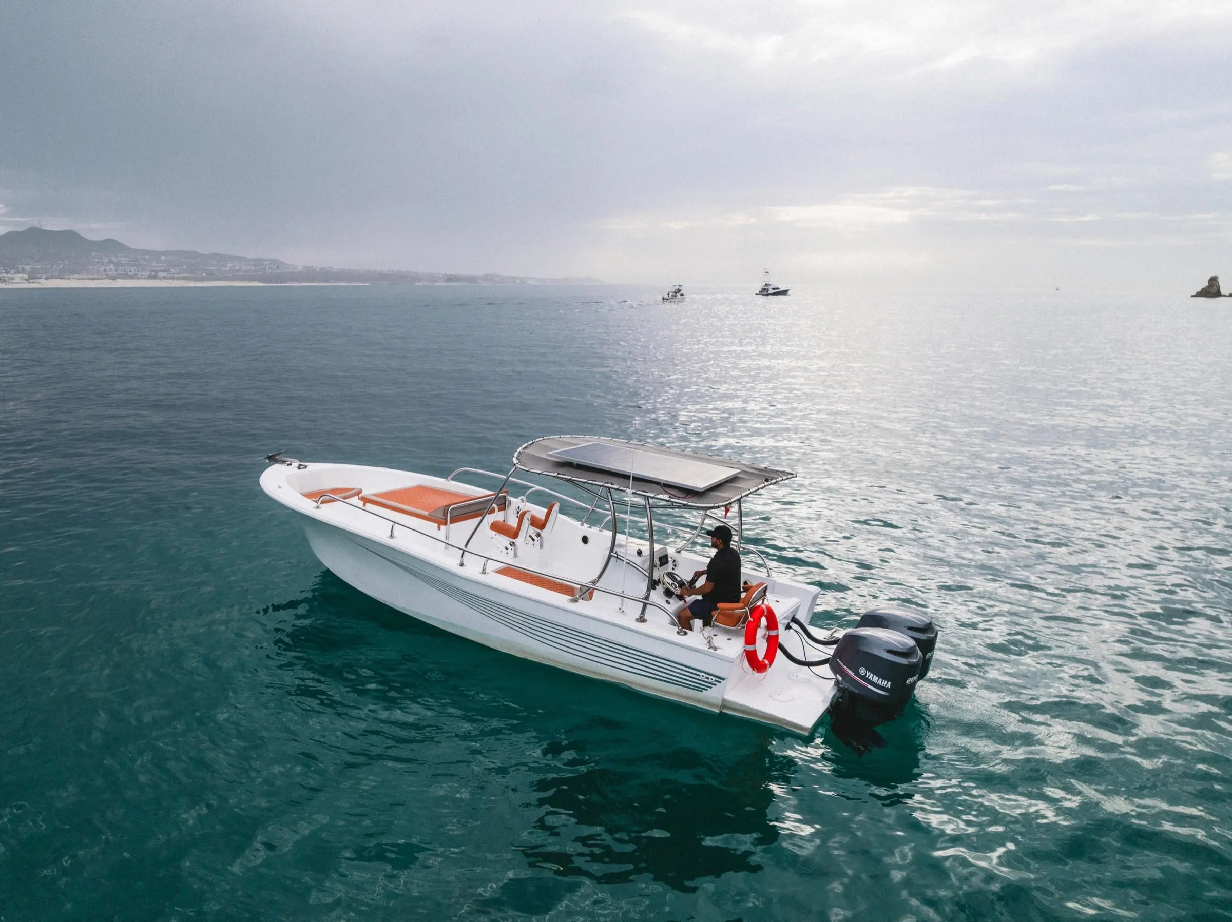 Pelican Cabo 33ft expedition boat anchored off Cabo San Lucas with Land's End in the background
