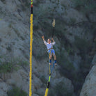 Man waving from suspended gondola in bungee jump