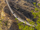Two Can-Am Maverick UTVs crossing the Wild Canyon suspension bridge across a desert canyon in Los Cabos