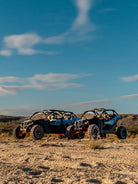 Two Can-Am Maverick UTVs parked in the open desert under a wide sky at Wild Canyon Adventures, Los Cabos
