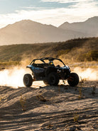 Can-Am Maverick UTV kicking up dust at sunset with mountains at Wild Canyon Adventures, Los Cabos