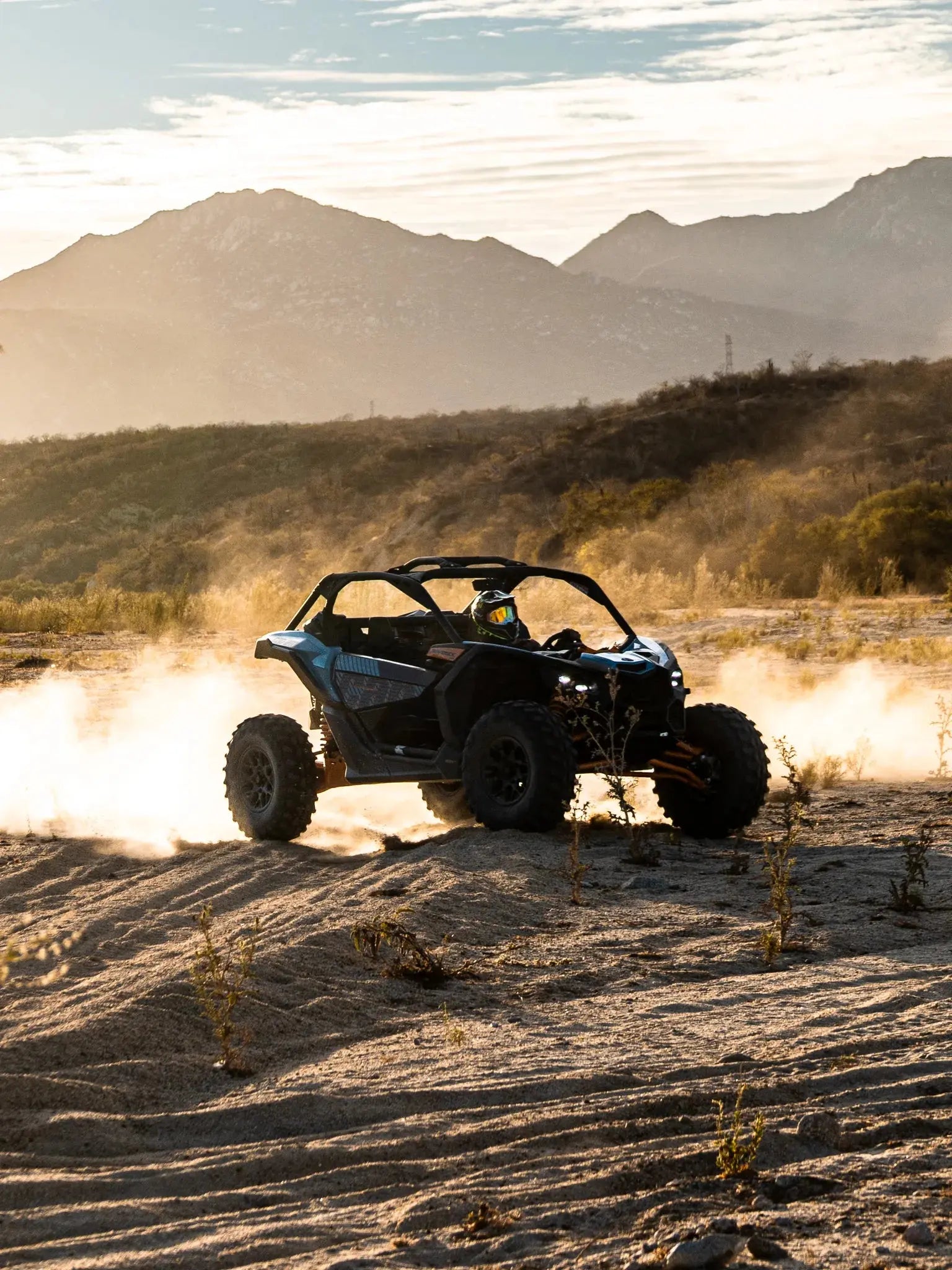 Can-Am Maverick UTV kicking up dust at sunset with mountains at Wild Canyon Adventures, Los Cabos