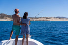 Couple fishing from the bow of a Pelican Cabo expedition boat along the Baja coastline